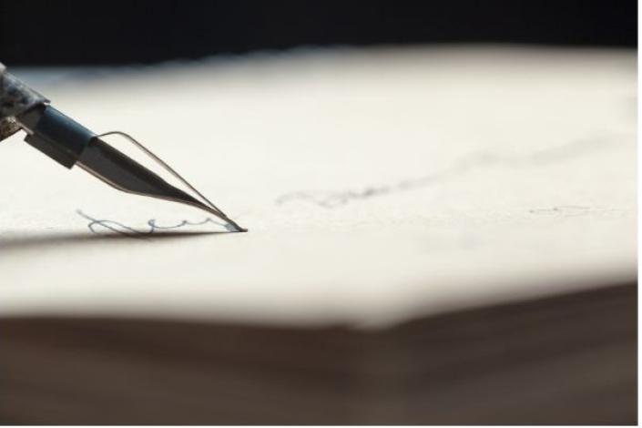 close up of fountain pen tip writing on a piece of paper