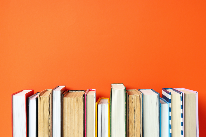 books facing page out on an orange background
